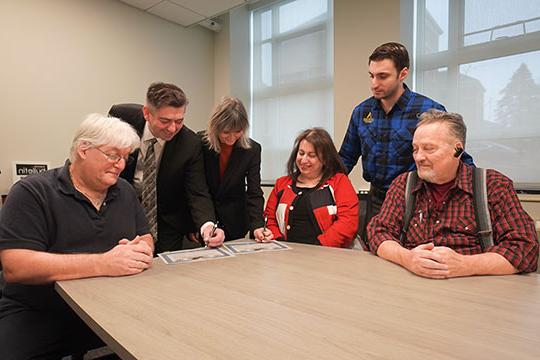 six people, two signing papers