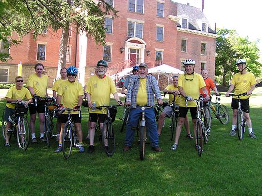 group of bicyclists in front of a brick 建筑